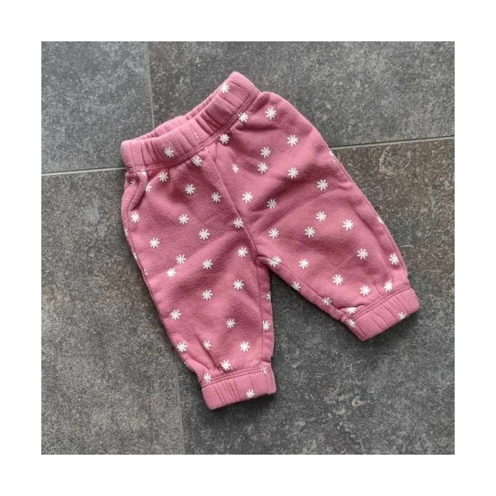 Pantalon rose à fleurs blanches.

Ceinture élastique