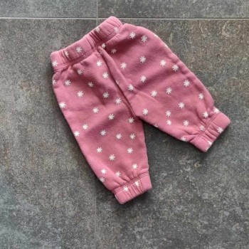 Pantalon rose à fleurs blanches.

Ceinture élastique