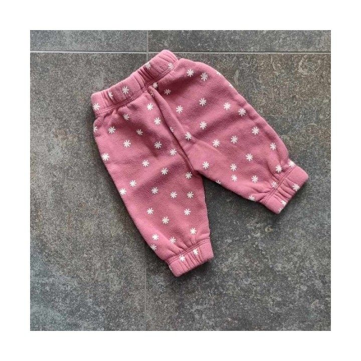 Pantalon rose à fleurs blanches.

Ceinture élastique